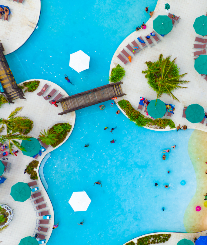 An aerial shot of a pool with people swimming in it.